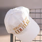 White cap with gold lettering