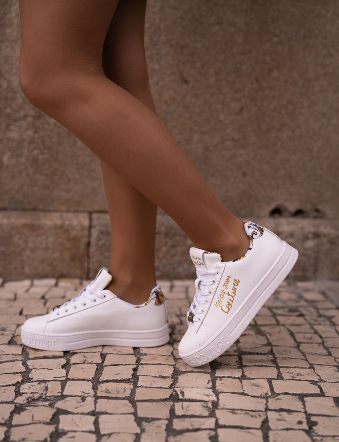 White sneaker with gold lettering