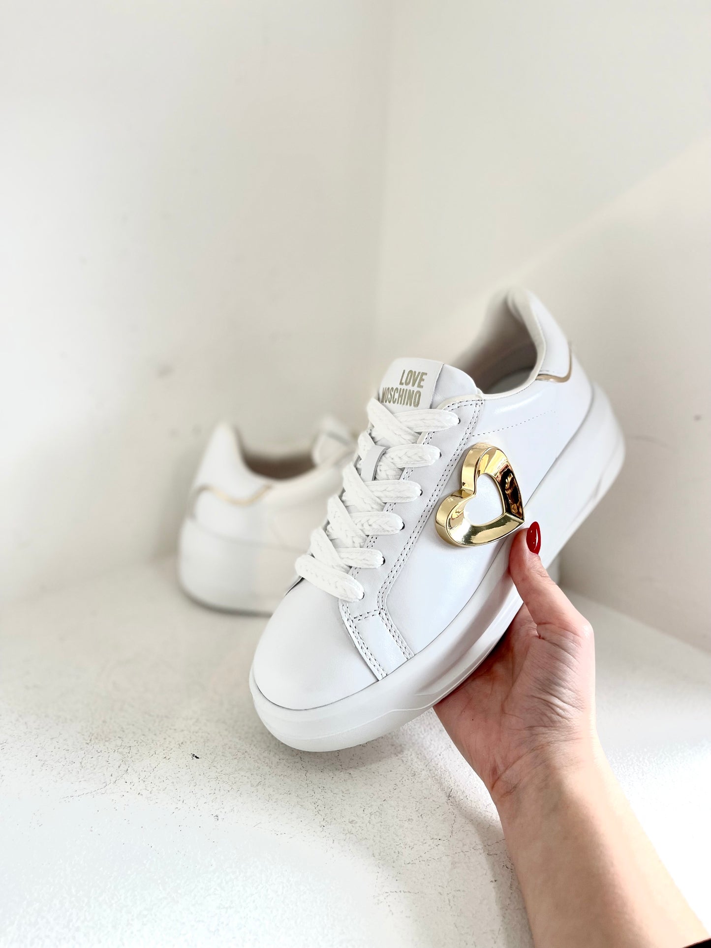 White sneaker with gold heart