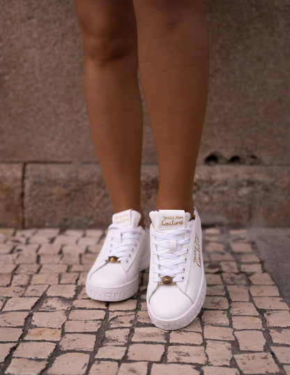 White sneaker with gold lettering