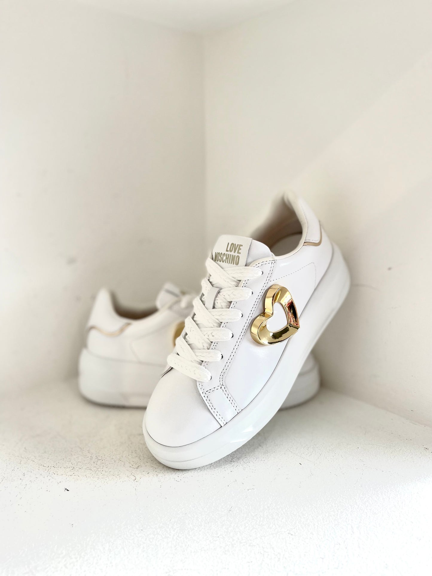 White sneaker with gold heart